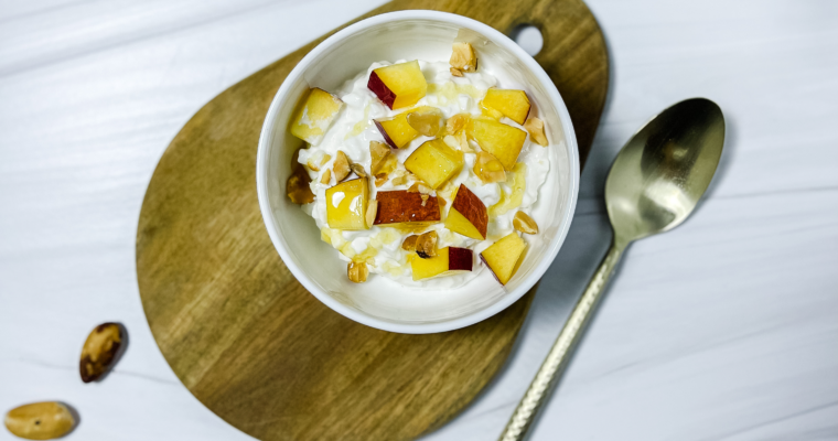 a refreshing and tasty bowl of peach cottage cheese with brazil nuts and honey